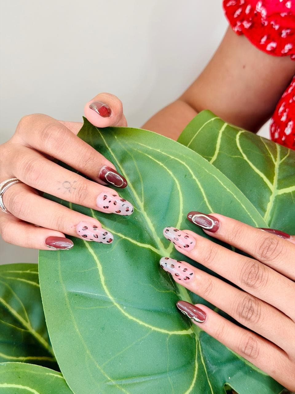 Leopard-print nail art over greenery